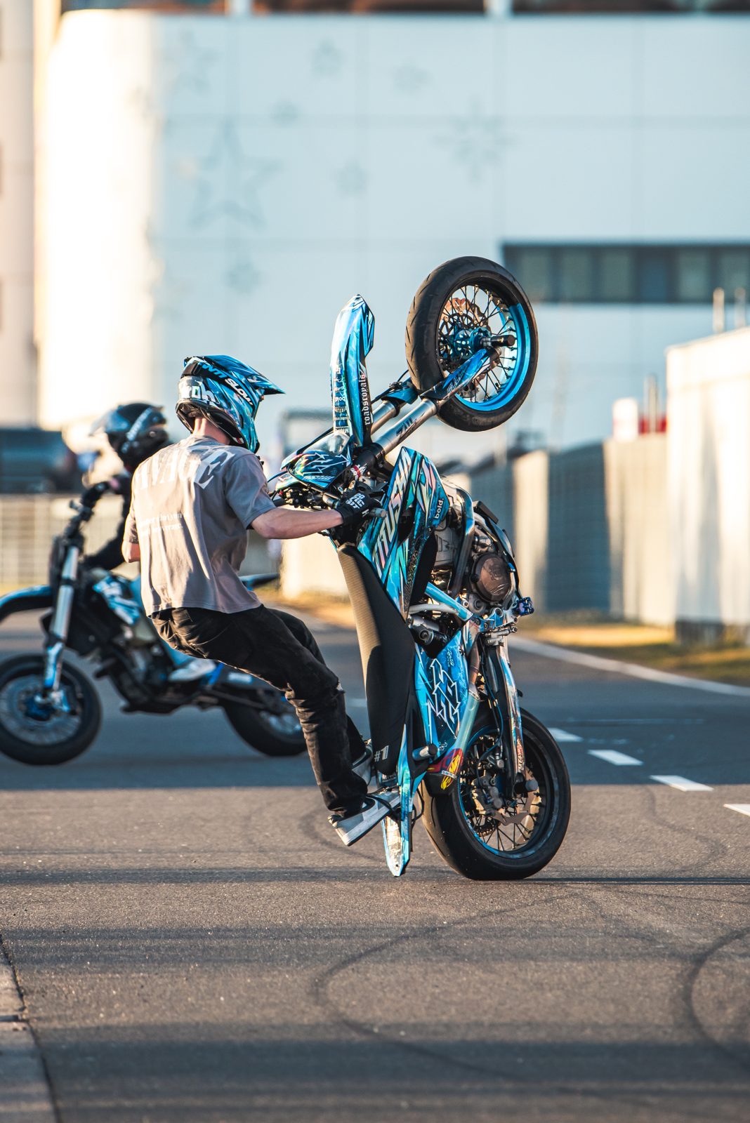 Wheelie mit zweitem Fahrer im Hintergrund