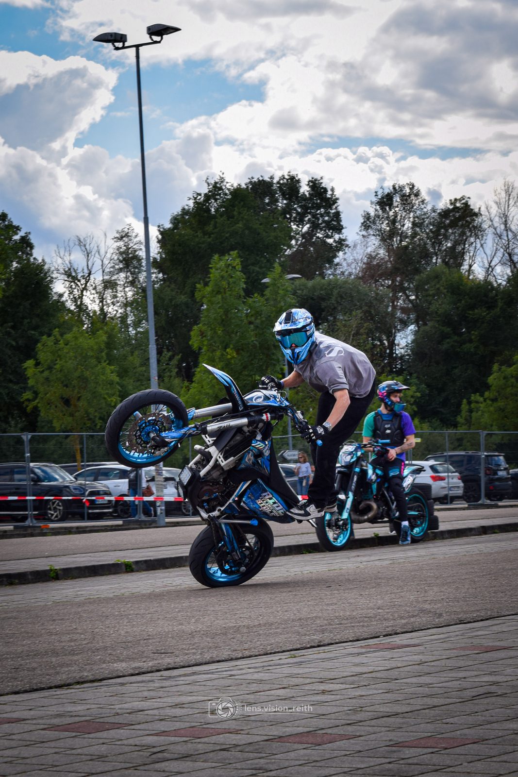 Wheelie mit zweitem Fahrer im Hintergrund
